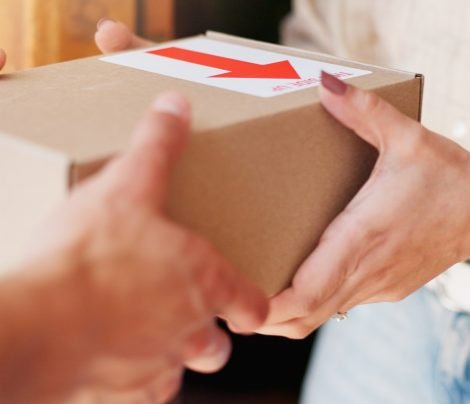 Delivery man, woman and hands with box in home for online shopping order, parcel distribution and safe cargo. Logistics, supply chain or customer with courier service at front door for ecommerce sale.